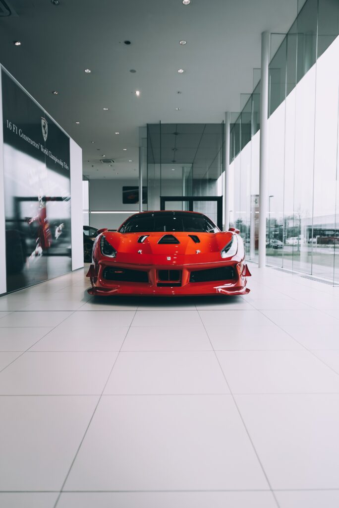 Sleek Red Sports Car Front View in Modern Showroom Wallpaper