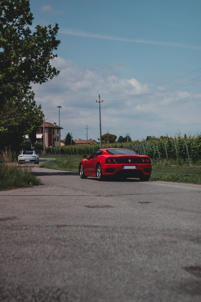 Stunning Red Sports Car on Country Road - Captivating Wallpaper