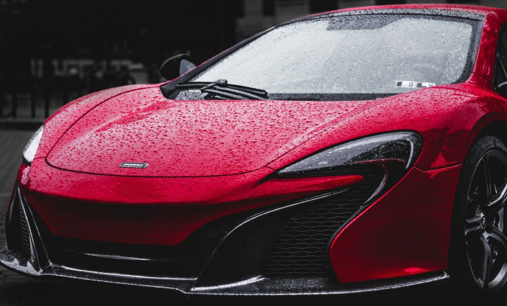Front View of Red Sports Car Wallpaper with Raindrops Background