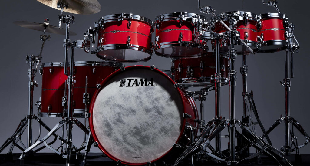 High-resolution red TAMA drum set with glossy finish and chrome hardware on grey background Wallpaper