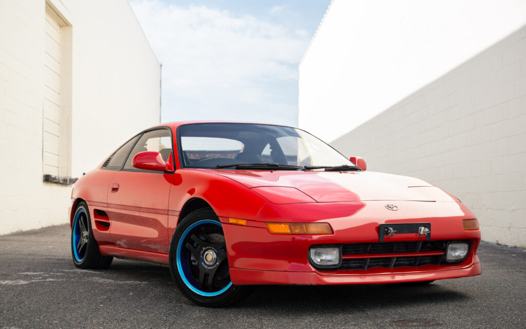 Red Toyota MR2: Iconic Sports Car Against Minimalist Background Wallpaper