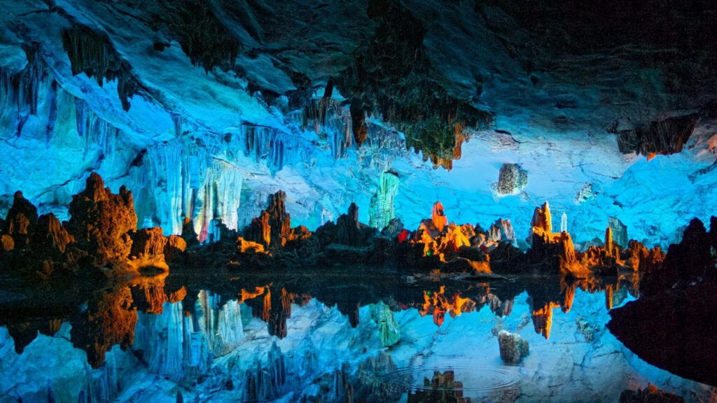 Stunning Reed Flute Cave Wallpaper: Vibrant Blue & Orange Illumination