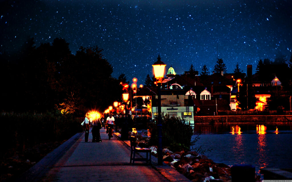 Serene Riga City Evening: Glowing Lights & Starry Sky Wallpaper