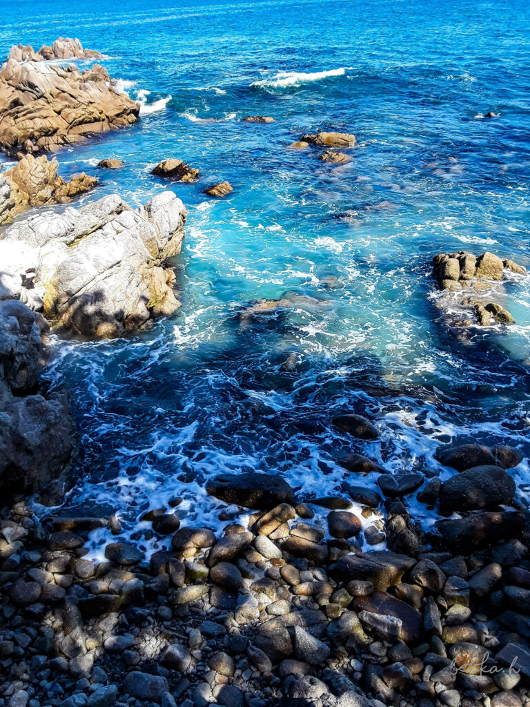 Stunning Rocky Shoreline Wallpaper: Vibrant Turquoise & Calming Waves