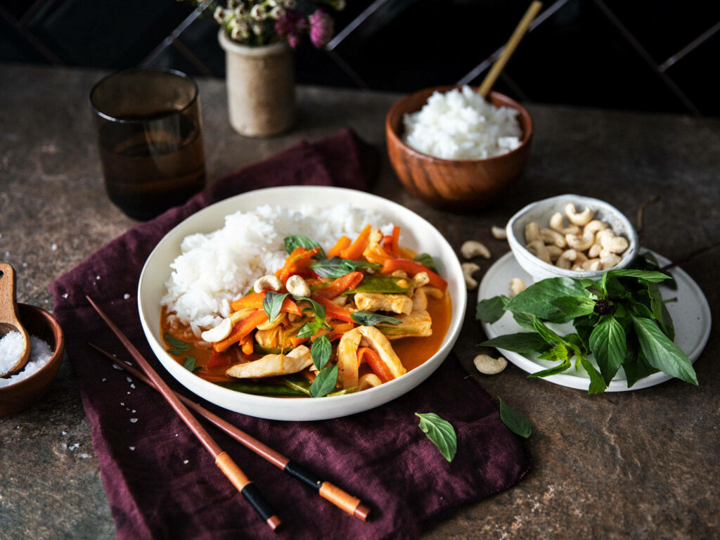 Vibrant Salmon Red Thai Curry Image with Baby Corn & Basil Wallpaper