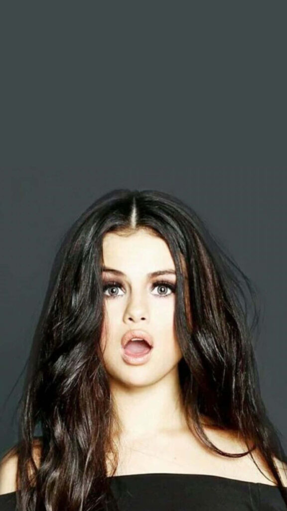 Captivating Selena Gomez Wallpaper: Expressive Look & Minimalist Background