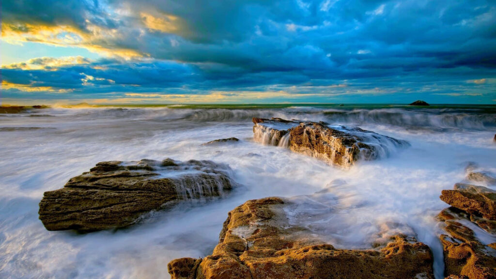 Vibrant Shoreline Wallpaper: Dramatic Ocean Waves & Clouds Background