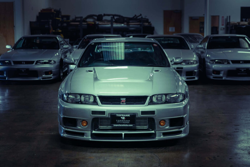 Nissan Skyline R33 GTR Wallpaper: Sleek Silver in Garage Setting