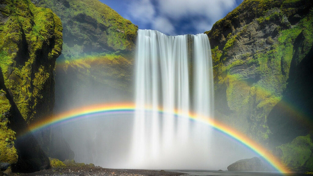 Enchanting Skógafoss Waterfall Wallpaper with Lush Greenery & Rainbows