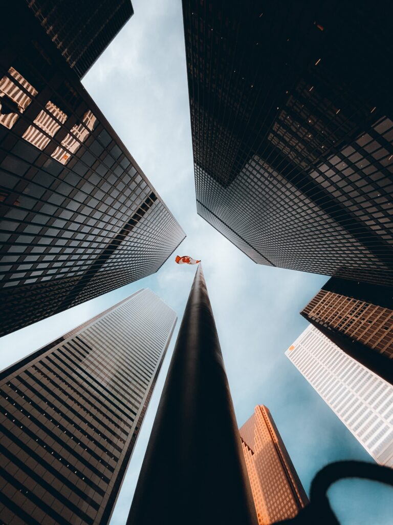 Canadian Pride: Skyscrapers from Below with Flag - Stunning Wallpaper