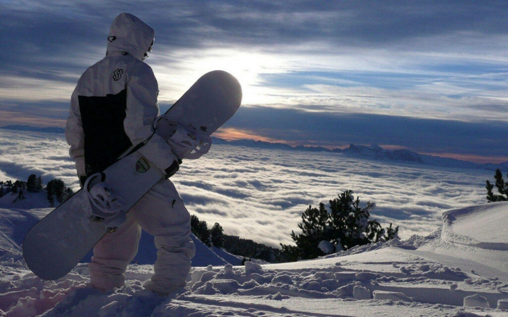 Lone Snowboarder on Mountain: Breathtaking Cloud-Filled Valley Wallpaper