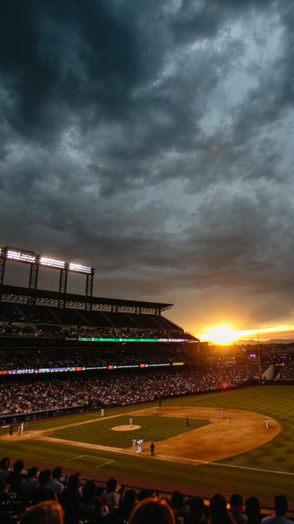 Vibrant Sunset Softball Game Wallpaper Background with Dramatic Clouds