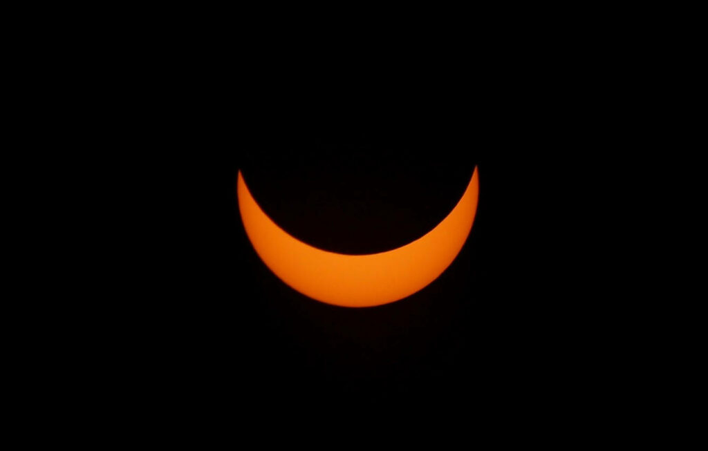 Stunning Solar Eclipse Wallpaper: Glowing Crescent in Dark Sky