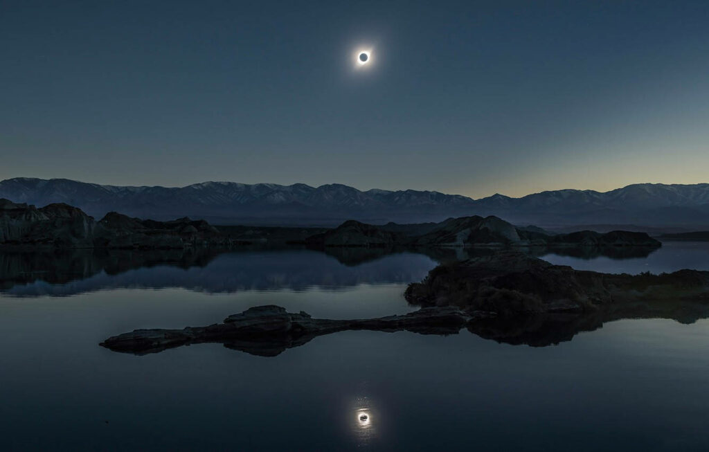 Serene Solar Eclipse Wallpaper Over Scottish Loch: Mystical Beauty