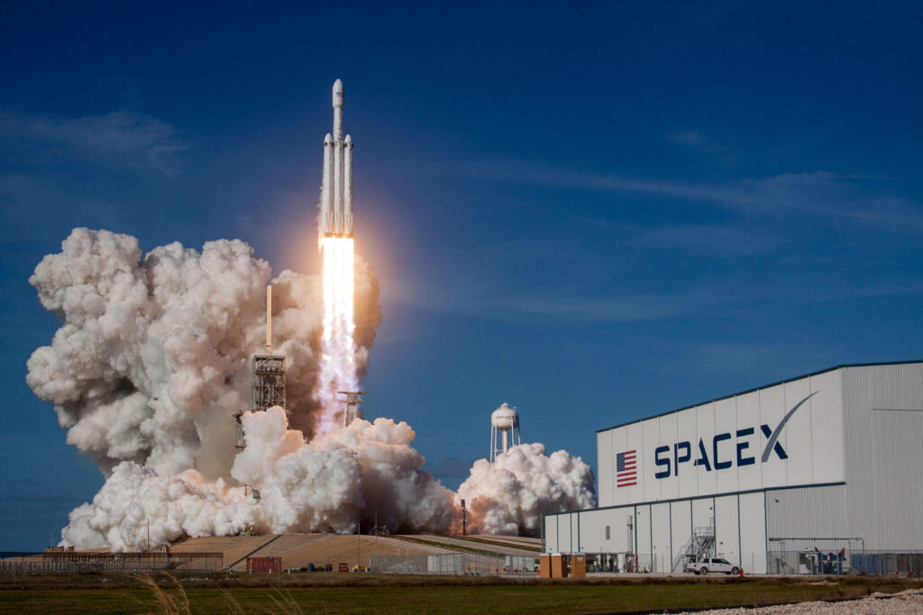 SpaceX Falcon Heavy Launch Wallpaper: Rocket Ascending Amidst Clouds