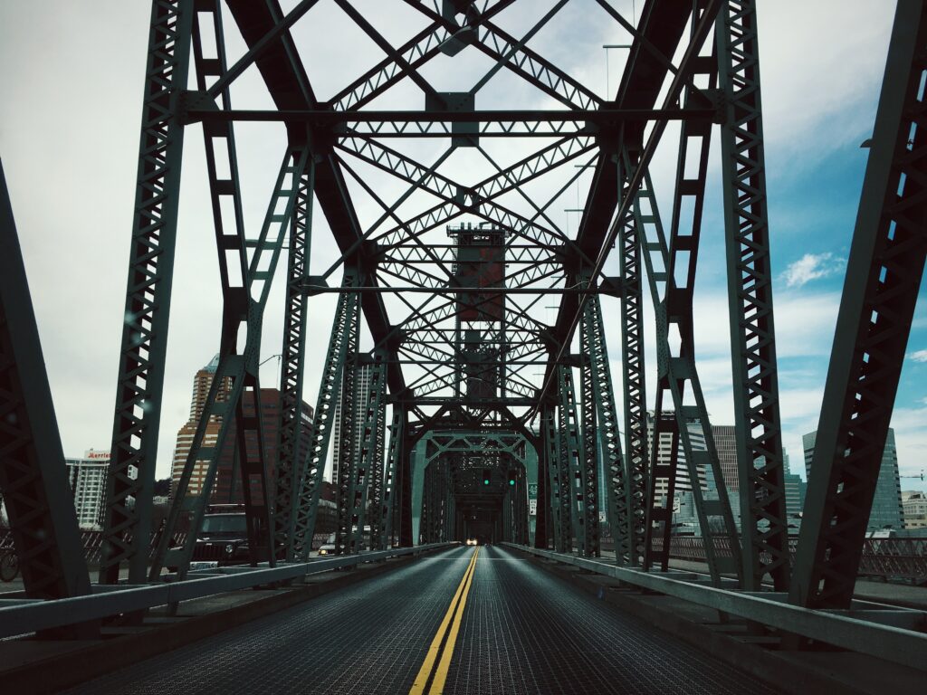 Intricate Steel Bridge Wallpaper: Urban Skyline & Cloudy Sky Backdrop