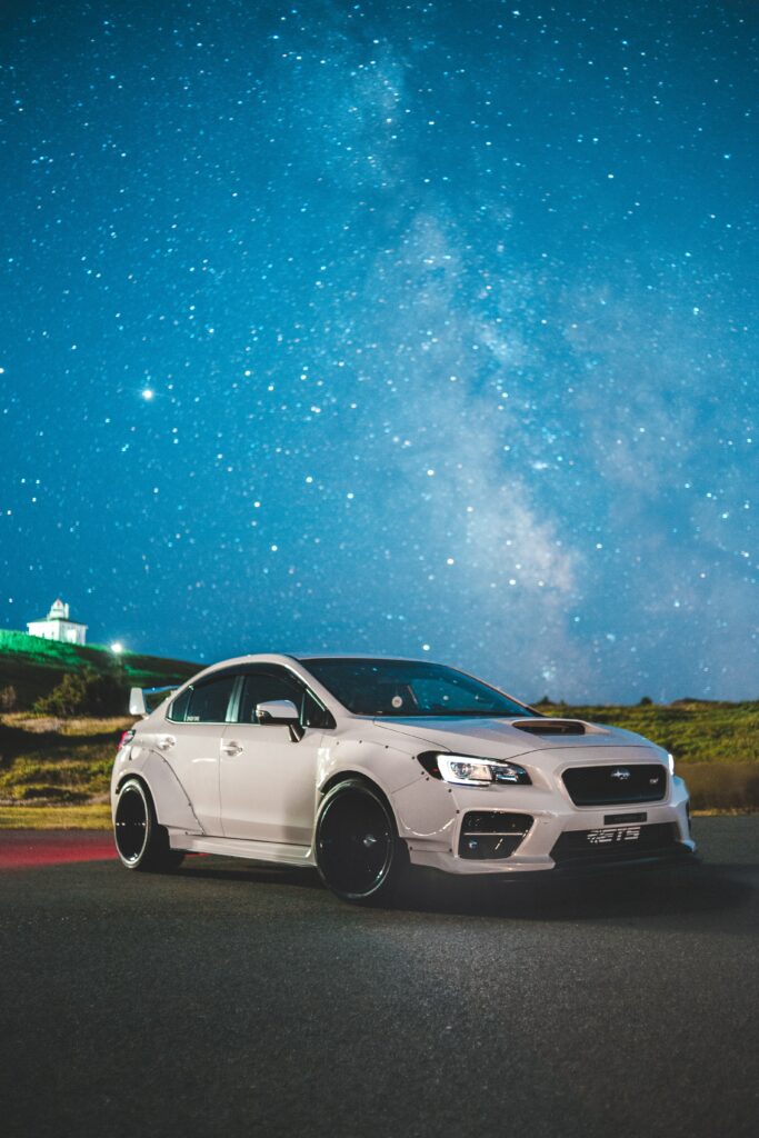 Sporty White Subaru with Spoiler Against Starry Night Sky Wallpaper