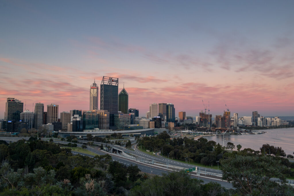 Stunning Sunset Cityscape Wallpaper: Modern Buildings & Serene Waterfront
