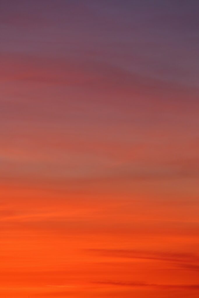 Sunset wallpaper with gradient sky of reds oranges and purples creating a soothing background