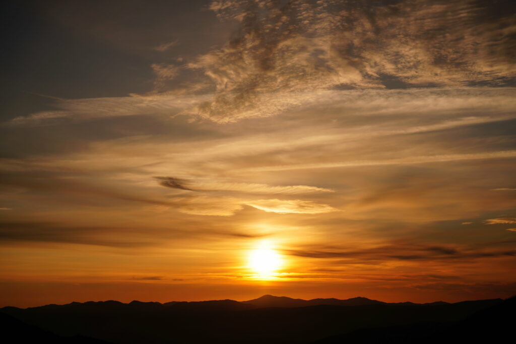 Stunning Sunset Wallpaper: Warm Golden Hues Over Distant Hills