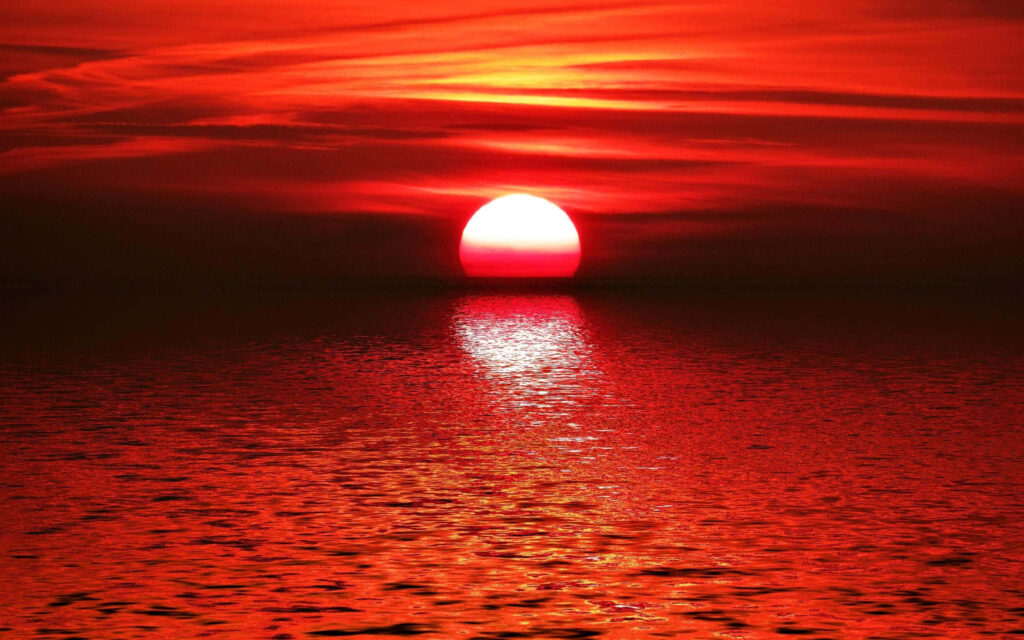 Vibrant Sunset Over Beach: Red & Orange Hues Reflect on Ocean Wallpaper