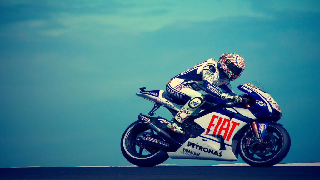 Stunning Superbike Wallpaper: Rider in Gear Against Blue Sky