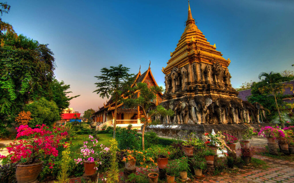 Stunning Thailand Wallpaper: Golden Temple Amid Lush Greenery & Flowers