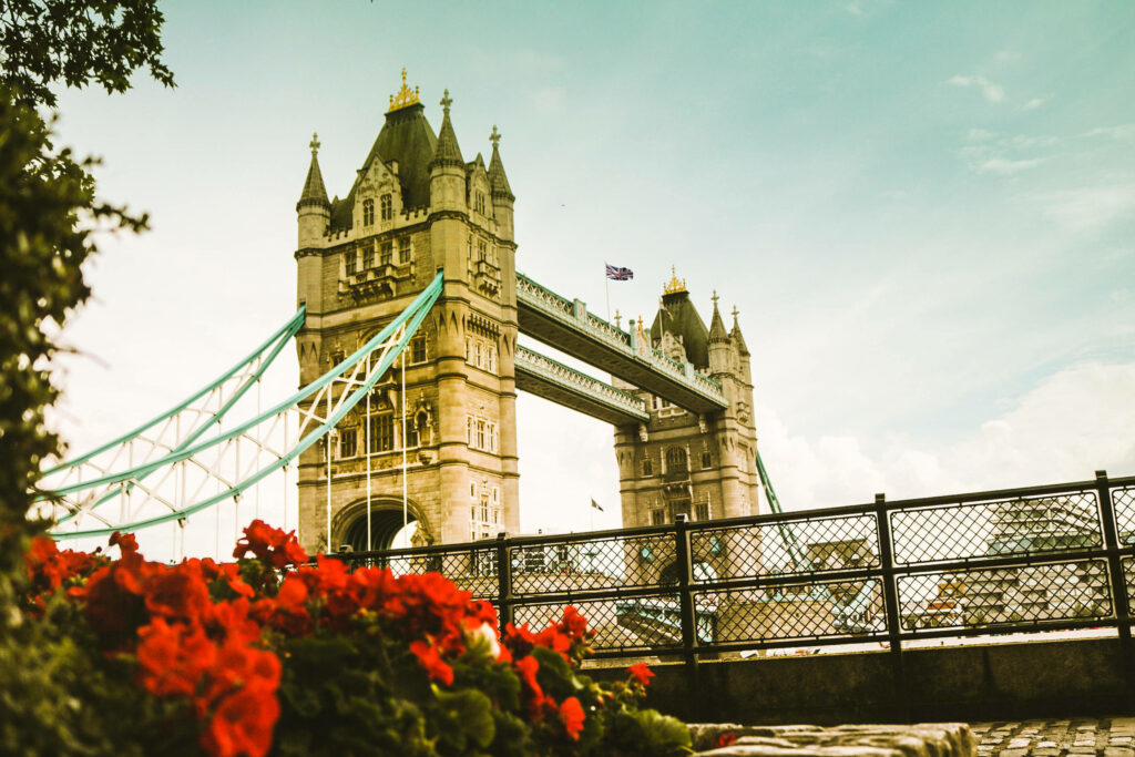 Stunning Tower Bridge Wallpaper with Red Flowers and Serene Sky