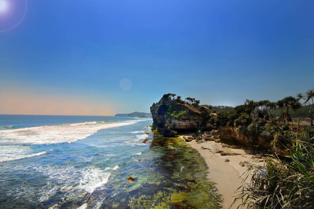 Stunning Tropical Beach Wallpaper with Waves and Lush Greenery
