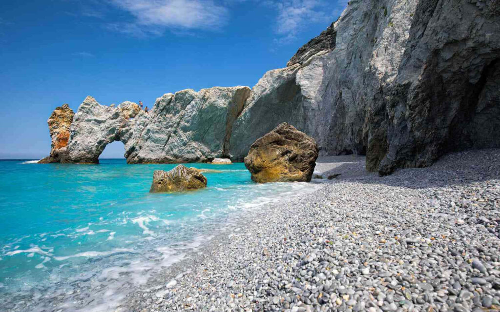 Turquoise Waters and Rocky Formations: Stunning Beach View Background Wallpaper