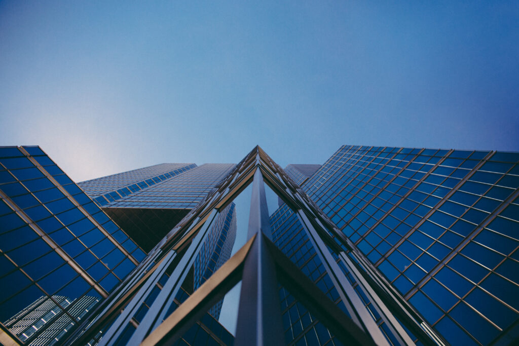 Dramatic Glass Building Facade Wallpaper with Vibrant Sky Reflection