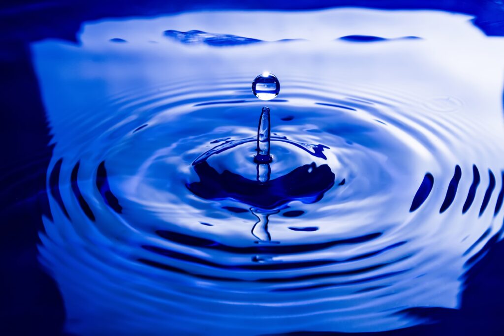 Mesmerizing Water Drop Ripples on Vibrant Blue Wallpaper Background
