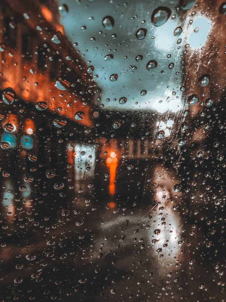 Water Droplets on Glass Wallpaper: Warm Streetlight Ambiance