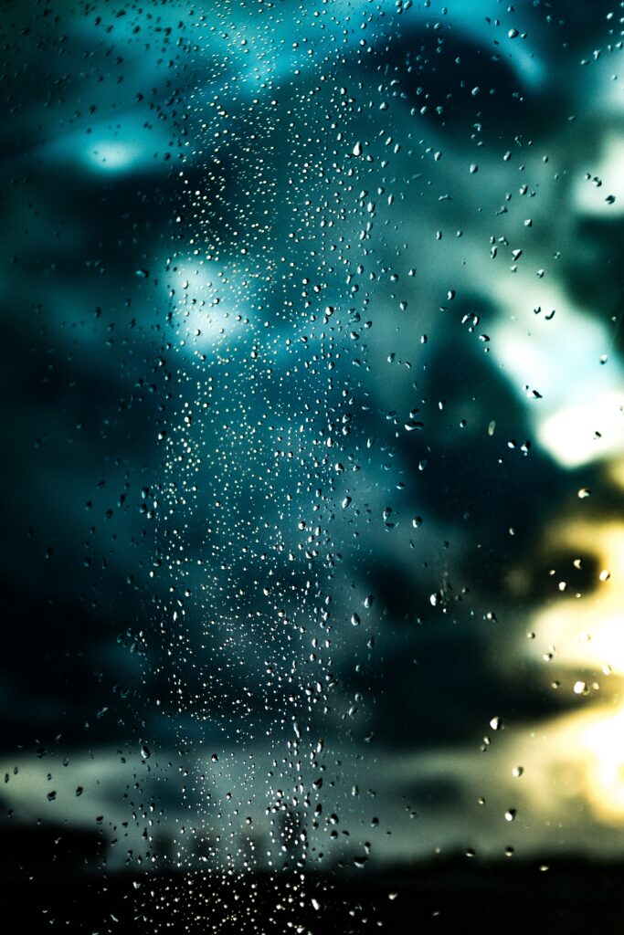 Water Droplets on Glass: Vibrant Cloudy Sky Wallpaper Background