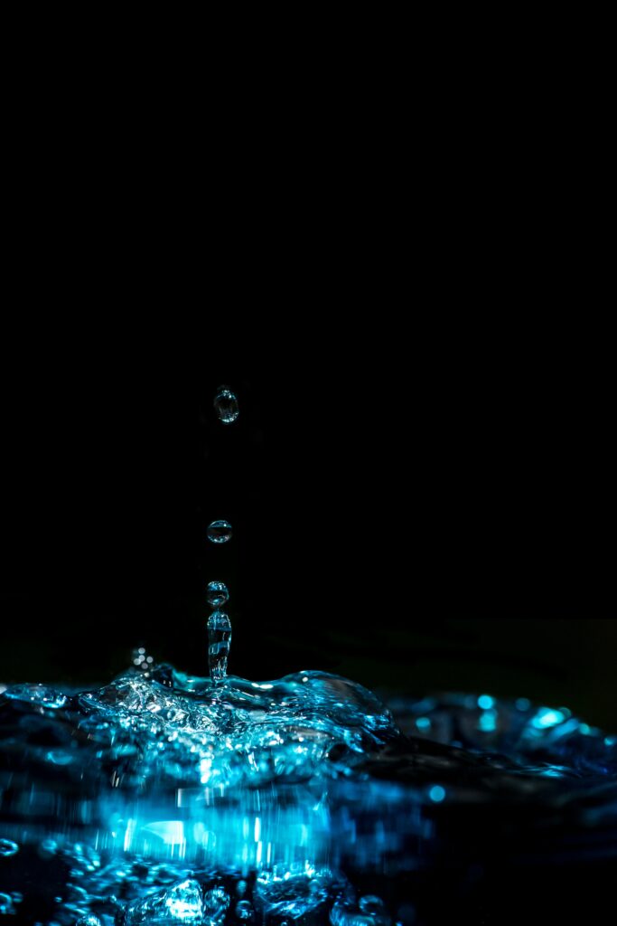 Glowing Water Drops Wallpaper: Beauty in Motion in Dark Setting