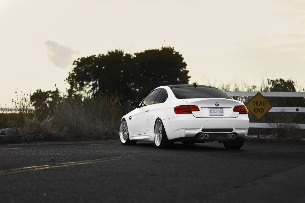 Sleek BMW M3 E92: Rear View on a Quiet Road Under Clear Skies Wallpaper