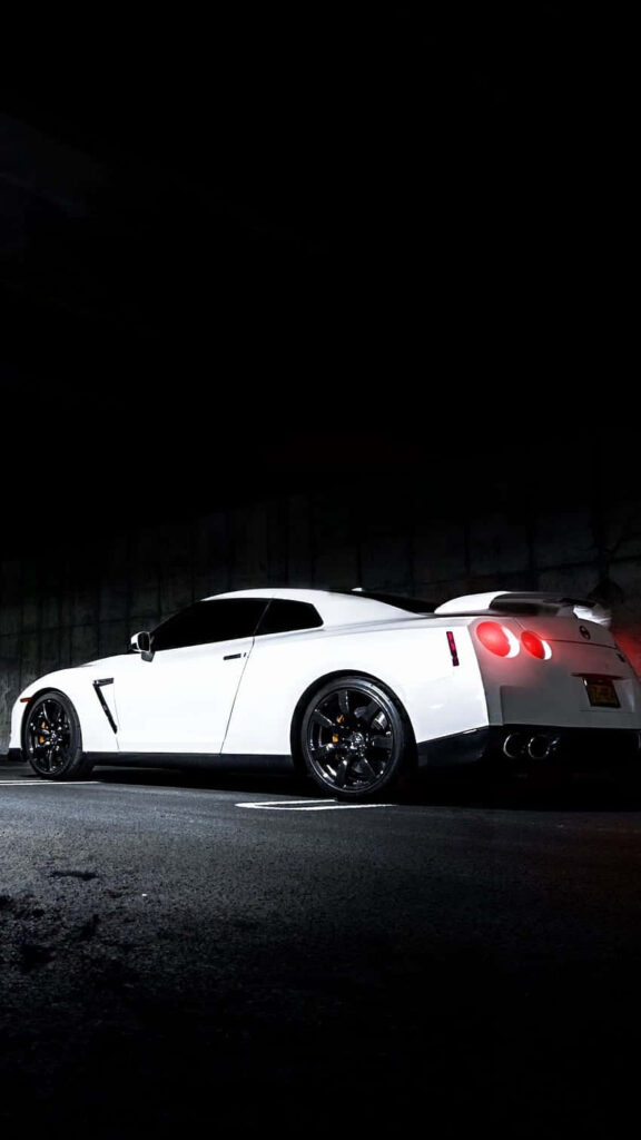 White GTR sports car wallpaper with dramatic lighting highlighting bold design and rear profile