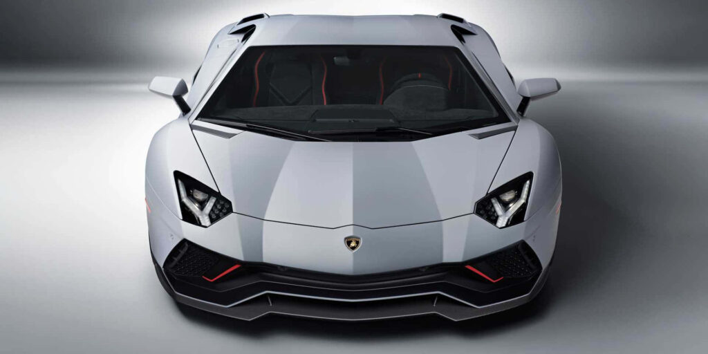 Front view of white Lamborghini sports car with sharp lines aggressive headlights luxury design Wallpaper
