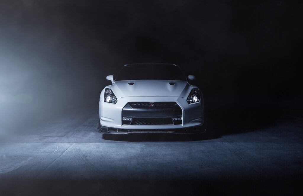White Nissan GT-R R35 Wallpaper: Dynamic Front View in Smoky Backdrop