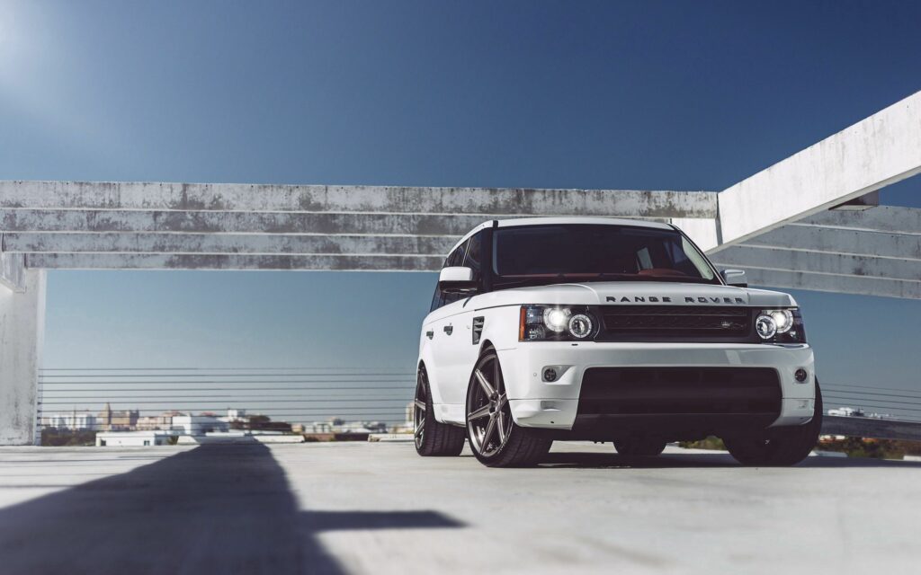 Stunning White Range Rover Under Modern Structure - Luxury Wallpaper