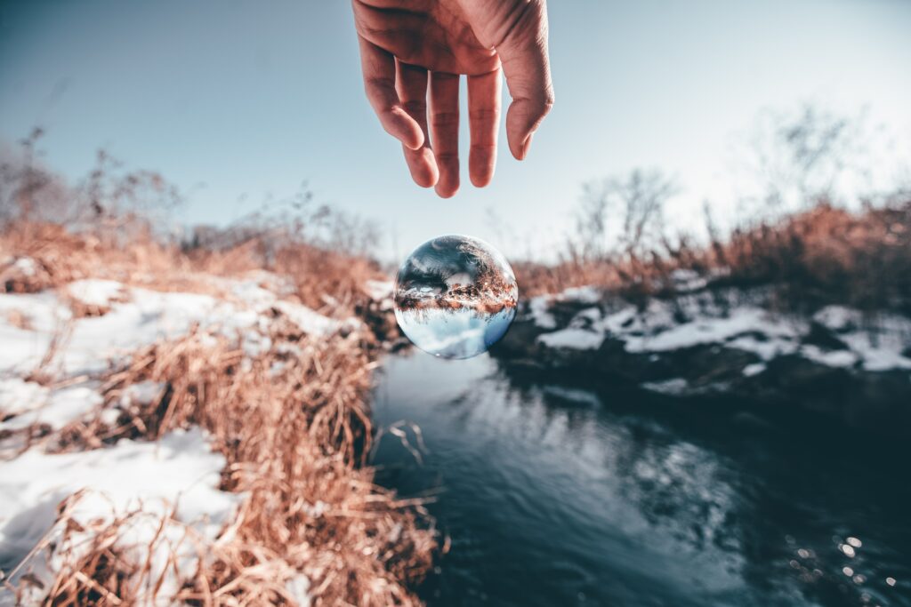 Elegant Winter Landscape Wallpaper: Hand Holding Glass Ball