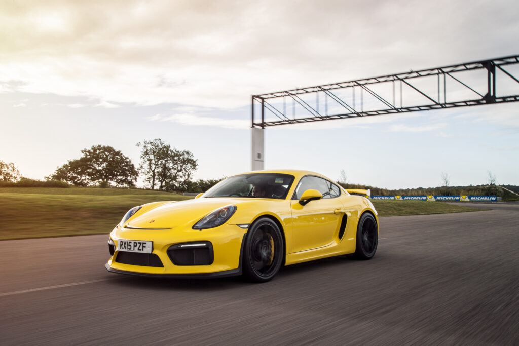 Stunning Yellow Porsche Cayman GT4 Racing Wallpaper - Track Performance