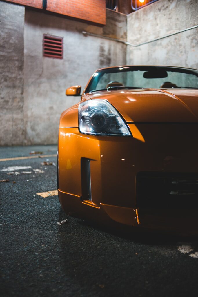Dynamic Yellow Sports Car Front View in Urban Setting Wallpaper