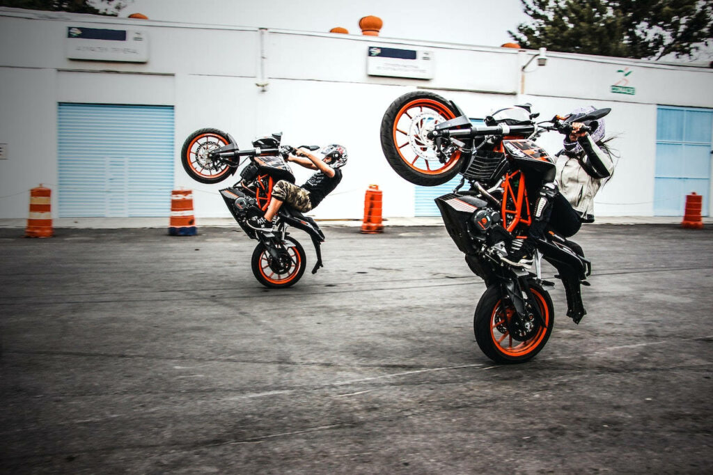 Stunt Riding Wallpaper: Impressive Wheelies on Sleek Motorcycles