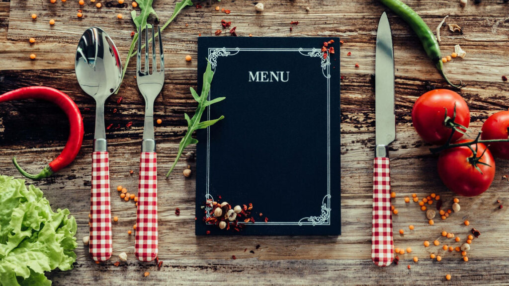 Rustic Black Menu Book with Fresh Veggies: Perfect Picnic Setup Wallpaper