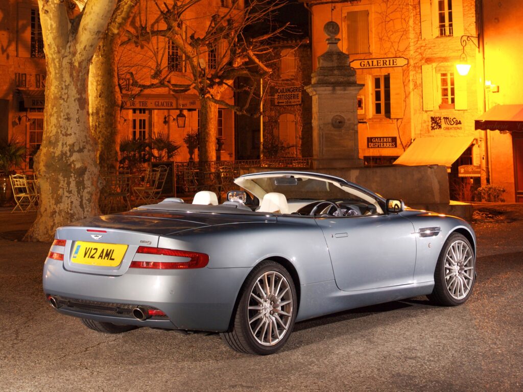 Stylish Blue 2004 Aston Martin DB9 Side View in Elegant Street Setting Wallpaper