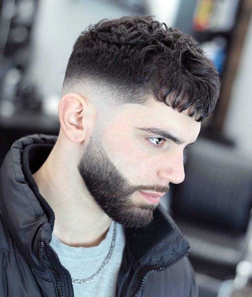 Stylish man with textured Caesar cut skin fade and thick beard in bright professional portrait Wallpaper