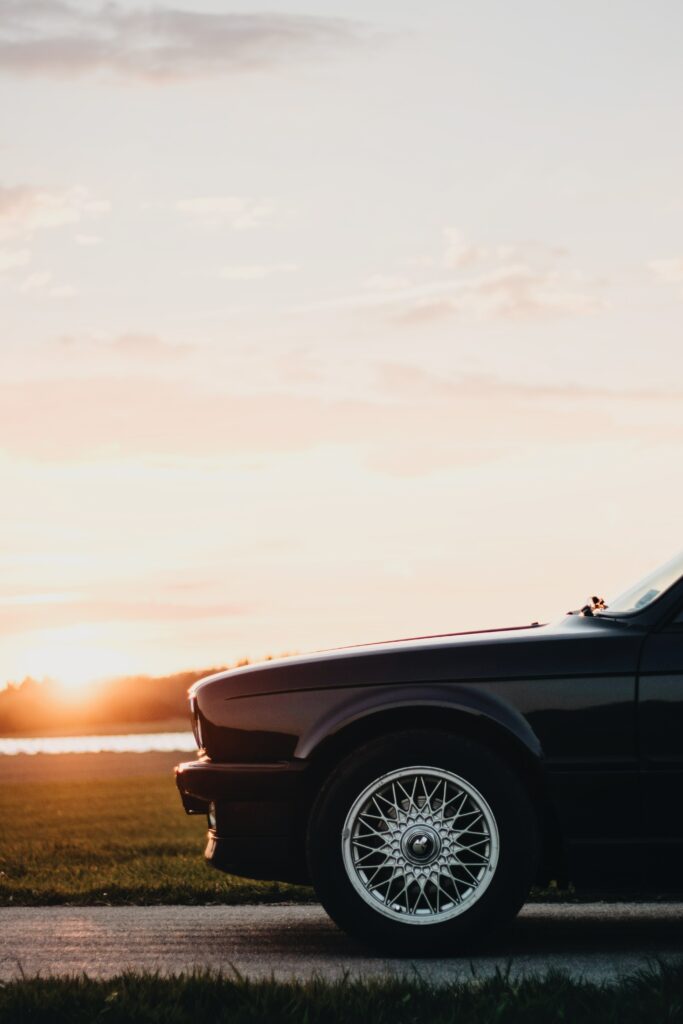 Stylish Car at Sunset: Sleek Design Meets Serene Landscape Wallpaper