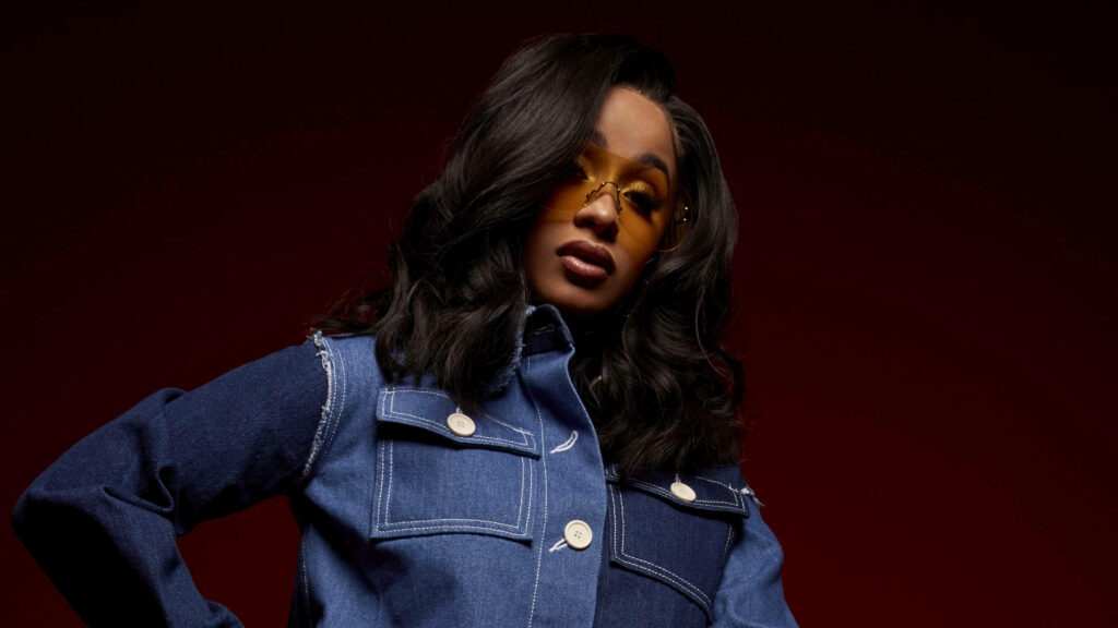 Chic Cardi B Wallpaper: Blue Jacket & Yellow Shades on Red Background