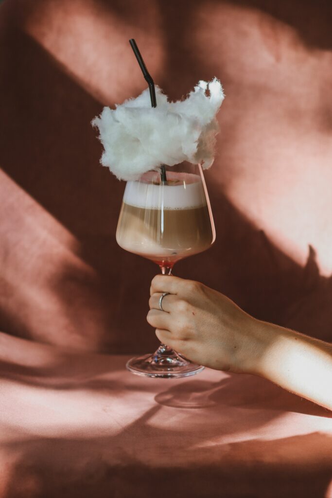 Stylish Cocktail with Cotton Candy Garnish - Warm Wallpaper Background